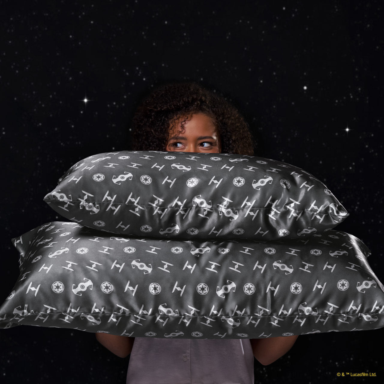 Model resting behind the Star Wars™ x Kitsch satin pillowcase showcasing the all-over character print — Standard — detail