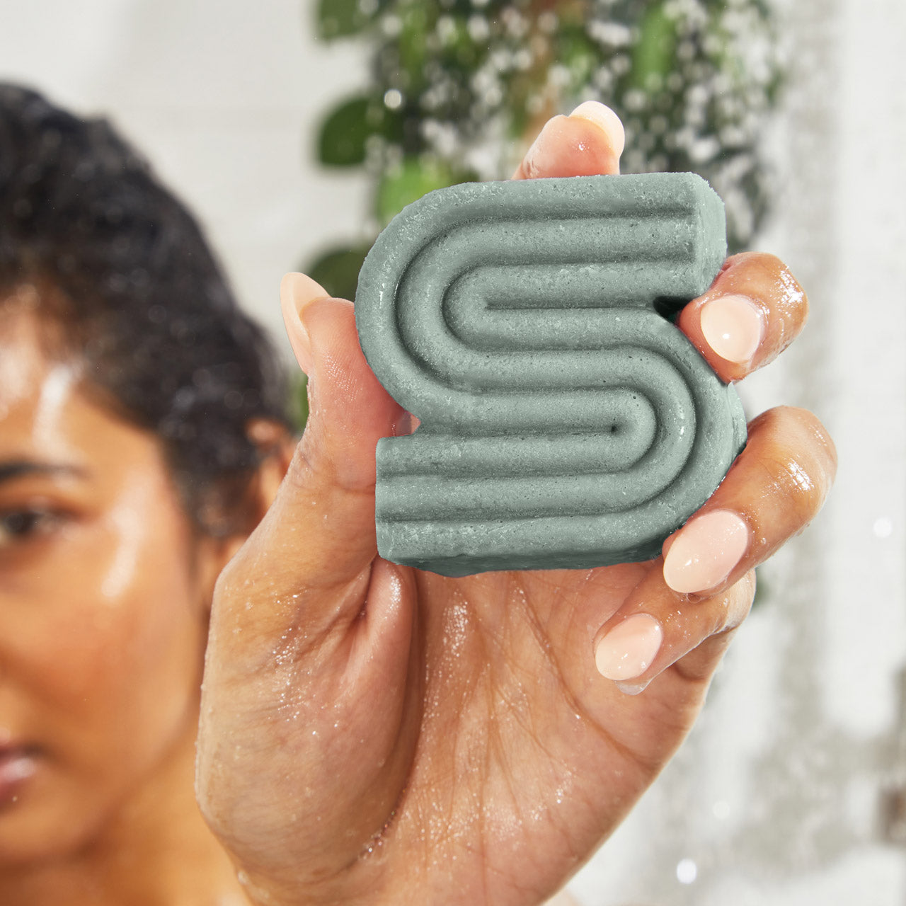 Model lathering Kitsch Rosemary & Biotin Volumizing Shampoo Bar in the shower for fuller-looking hair