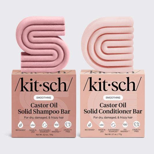 KITSCH Castor Oil Solid Shampoo Bar + Solid Conditioner Bar combo product lineup on light gray background — SMOOTHING Castor Oil Shampoo Bar (3.2 oz) and Conditioner Bar (2.7 oz) bars with retail boxes — For dry, damaged, & frizzy hair — Bio-based | Made in USA | Sustainably Sourced | 100 Washes | Cruelty-FreeTwo pink kitsch castor oil shampoo and conditioner bars with their respective boxes on a light gray background