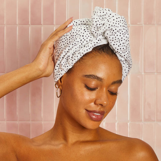 Model wearing the Kitsch Microfiber Hair Towel in Micro Dot, securely wrapped to help reduce drying time and minimize frizz.