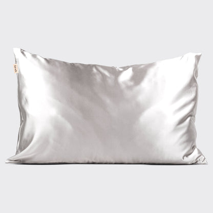 Kitsch Silver Satin Pillowcase styled on a bed with soft light and minimal bedding
