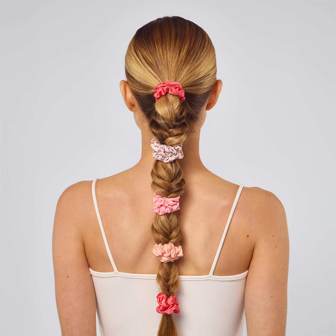 KITSCH Cherry Blossom Ruched Satin Scrunchies 5pc Set — model styling hair with cherry blossom ruched scrunchie — ruched satin design adds texture and a romantic floral feel