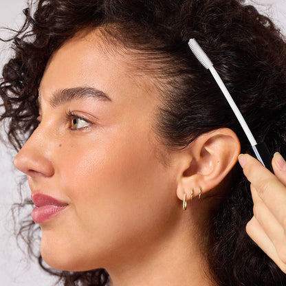 KITSCH Styling Taming Wand — close-up of spoolie applicator in use — Instantly tames frizz, flyaways, and baby hairs while boosting shine — compact packaging makes it easy to style on the go