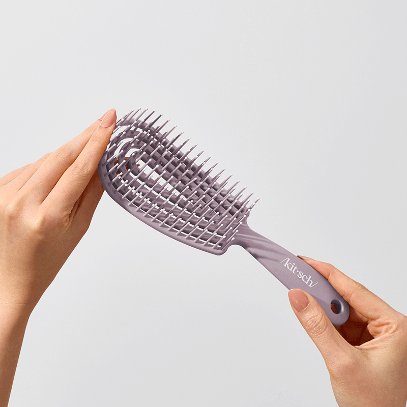 Model brushing through long hair with the Kitsch Soft Violet Detangling Flexi Brush