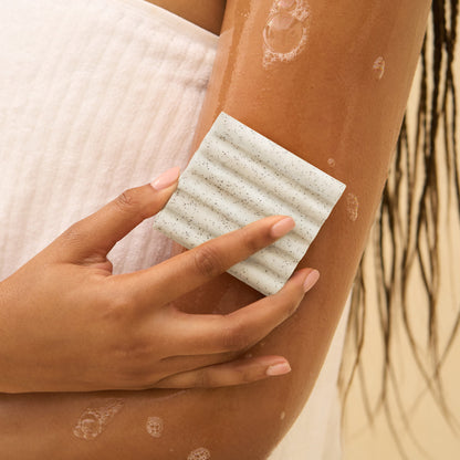 KITSCH Jojoba Bead Exfoliating Body Wash Bar — model holding bar — Sustainable exfoliation: jojoba beads are biodegradable and planet-conscious — free of parabens, phthalates, direct CMRs & PFAS
