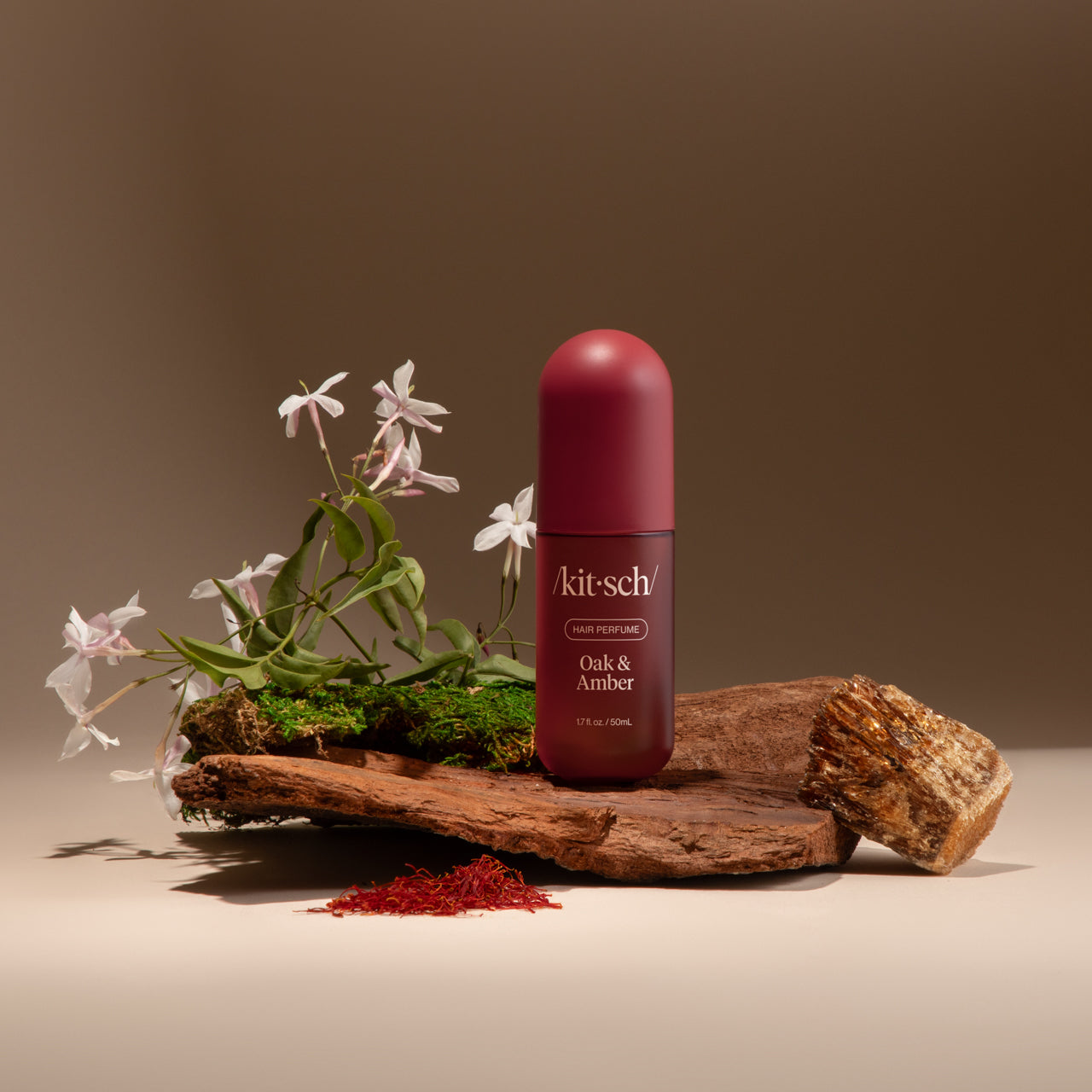 Model misting Kitsch Oak & Amber Hair Perfume onto smooth, glossy hair
