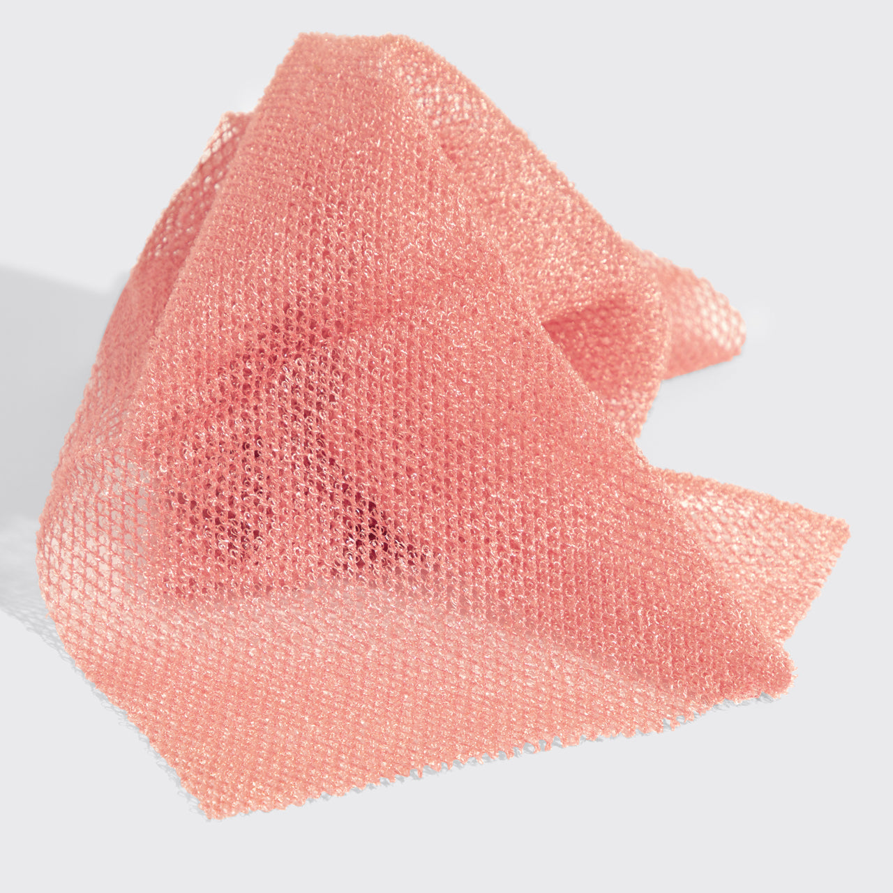 Close-up view of the Berry Pink African Net Sponge textured mesh material highlighting its exfoliating design.