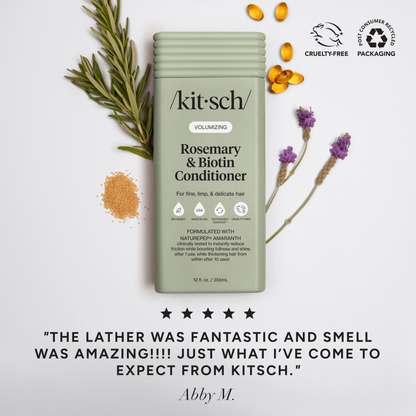 Marketing image for Kitsch Volumizing Rosemary & Biotin Conditioner (12 fl. oz.) styled with fresh rosemary, lavender, and biotin capsules. Similar to the shampoo ad, it features "Cruelty-Free" and "Post-Consumer Recycled Packaging" badges. A five-star testimonial from Abby M. reads, "The lather was fantastic and smell was amazing!!!! Just what I’ve come to expect from Kitsch".