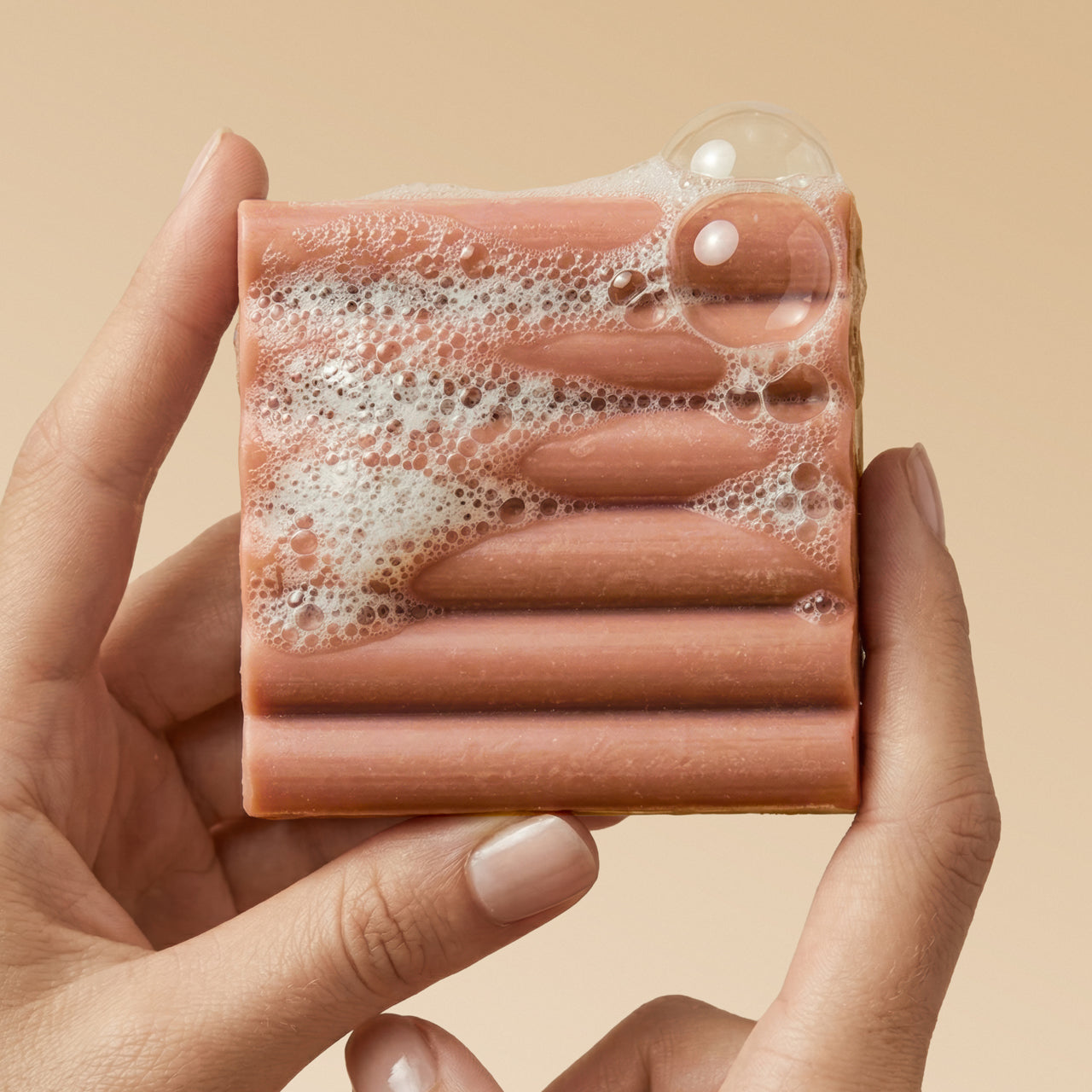 KITSCH Cleansing Amber Shores Body Wash Bar — close-up of bar with rich sudsy lather — Sudsy lather for a soft, luxurious cleanse — easy-grip design features a ridged shape for better handling and application
