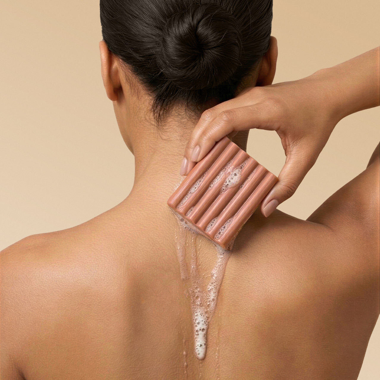 KITSCH Cleansing Amber Shores Body Wash Bar — model lathering bar on shoulder — Sudsy lather for a soft, luxurious cleanse — gentle yet effective body wash cleanses without stripping, perfect for daily use