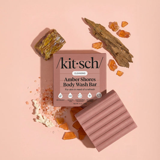 KITSCH Cleansing Amber Shores Body Wash Bar — lifestyle product shot with amber and driftwood props — Infused with breezy notes of sea salt, amber, and driftwood — leaves skin wrapped with a woody aquatic scent