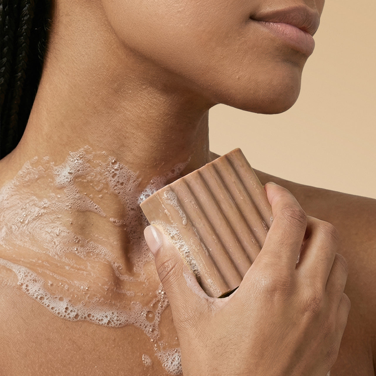 KITSCH Cleansing Warm Sugar Body Wash Bar — model lathering bar on shoulder — Sudsy lather for a soft, luxurious cleanse — gentle yet effective body wash cleanses without stripping, perfect for daily use