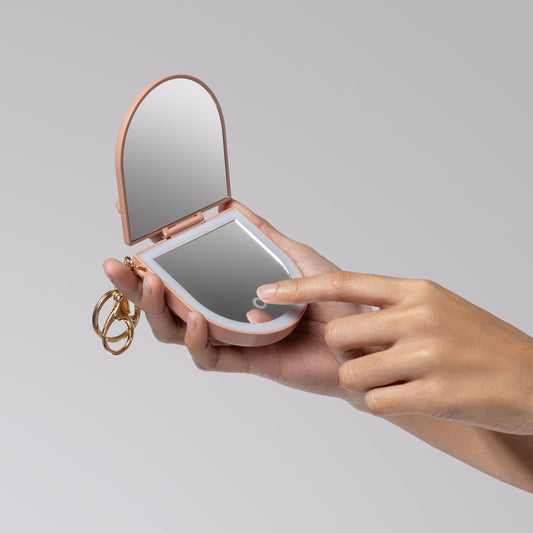 KITSCH Terracotta Compact Mirror Keychain — model lifestyle shot — compact mirror keychain used on the go for quick beauty touch-ups