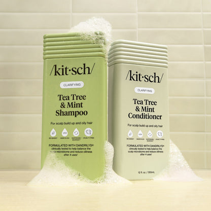 Kitsch Tea Tree & Mint Shampoo and Conditioner bottles on a tiled bathroom background