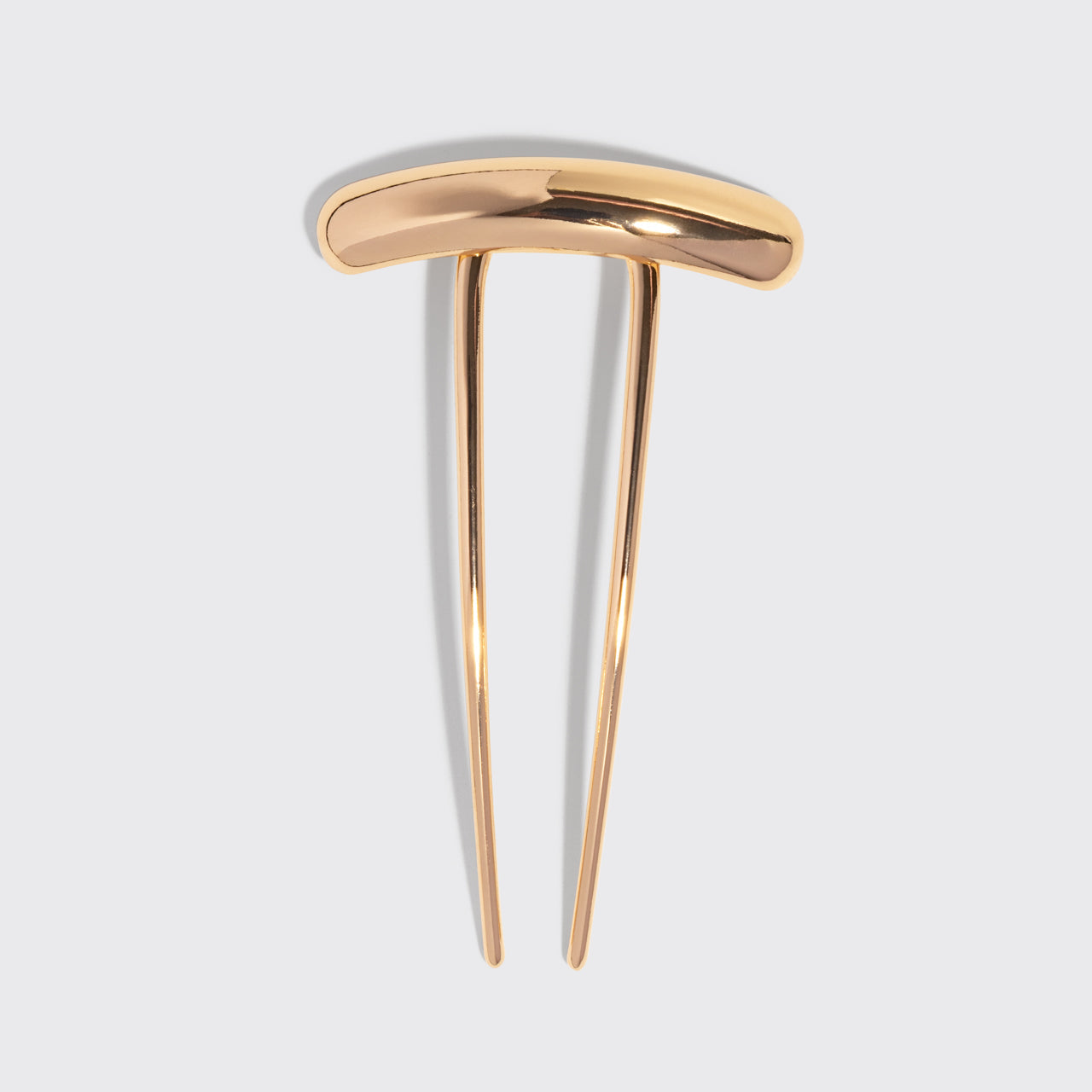 Gold barrette french hair pin on a light gray background