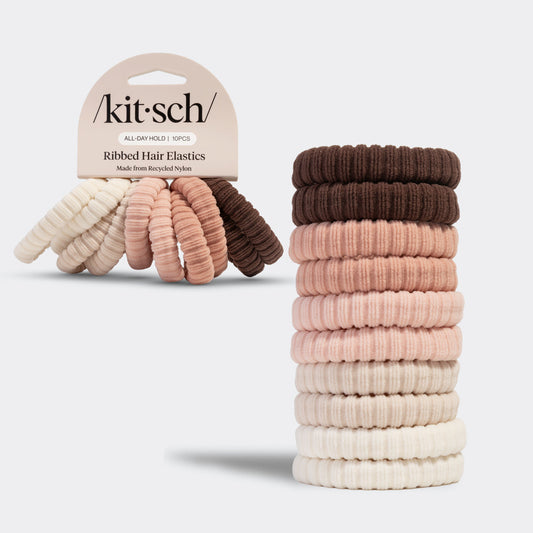 Stack of kitsch blush ribbed hair elastics with the packaged version of the hair elastics on a light gray background