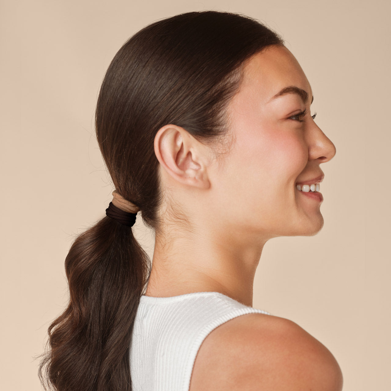 Sedona Seamless Hair Elastics 12pc Set - model side profile with dark hair in low ponytail wearing sedona seamless hair elastic