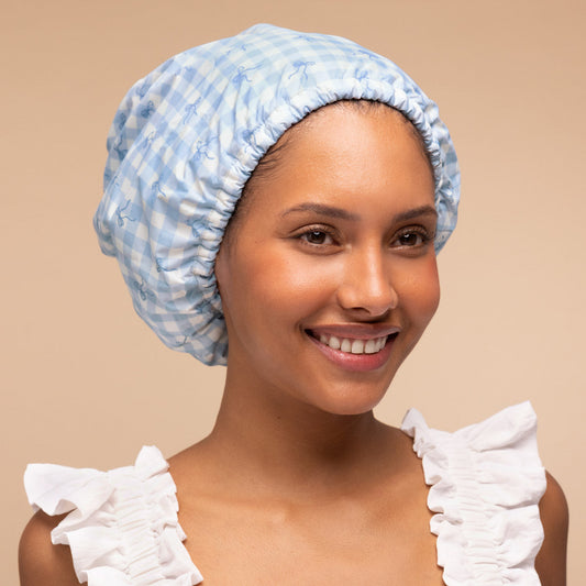 Model wearing the Kitsch Satin-Lined Flexi Shower Cap in Gingham Blue, showing the extra-wide fit that covers all hair
