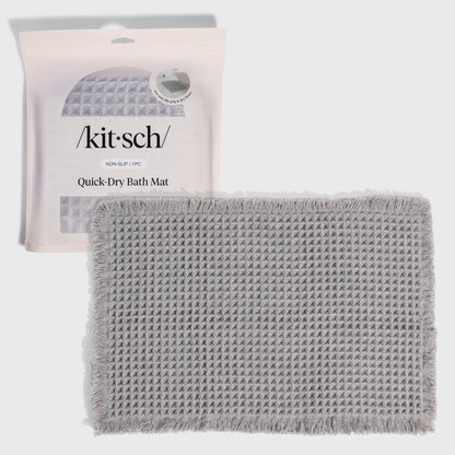 Kitsch Quick-Dry Bath Mat in gray hero image, shown with its retail packaging (non-slip, 1 piece) behind the folded mat.