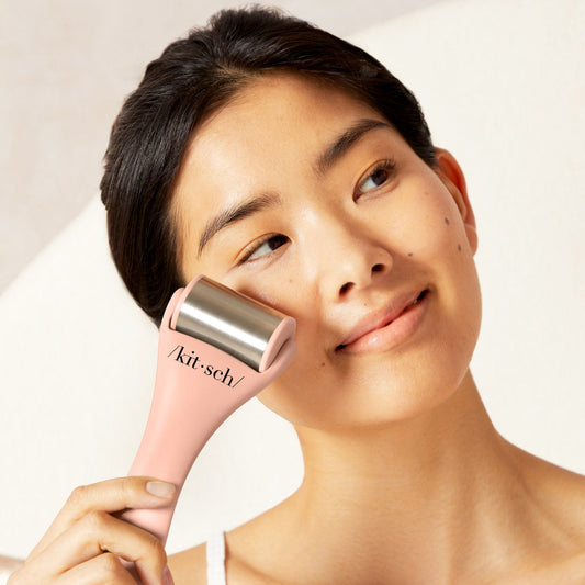 Model using Terracotta Ice Roller on cheekbone in upward stroke motion