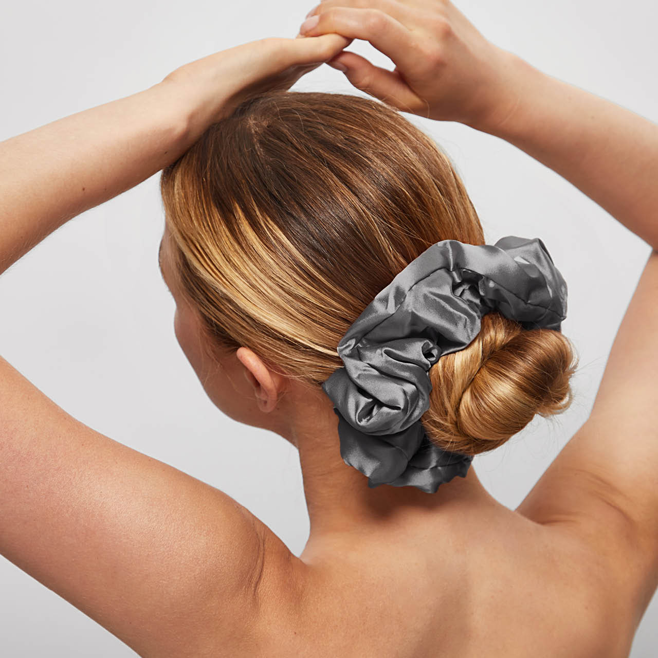KITSCH Charcoal & Gold Satin Pillow Scrunchies — model sleeping with charcoal satin pillow scrunchie — pillow-soft design is gentle on hair overnight