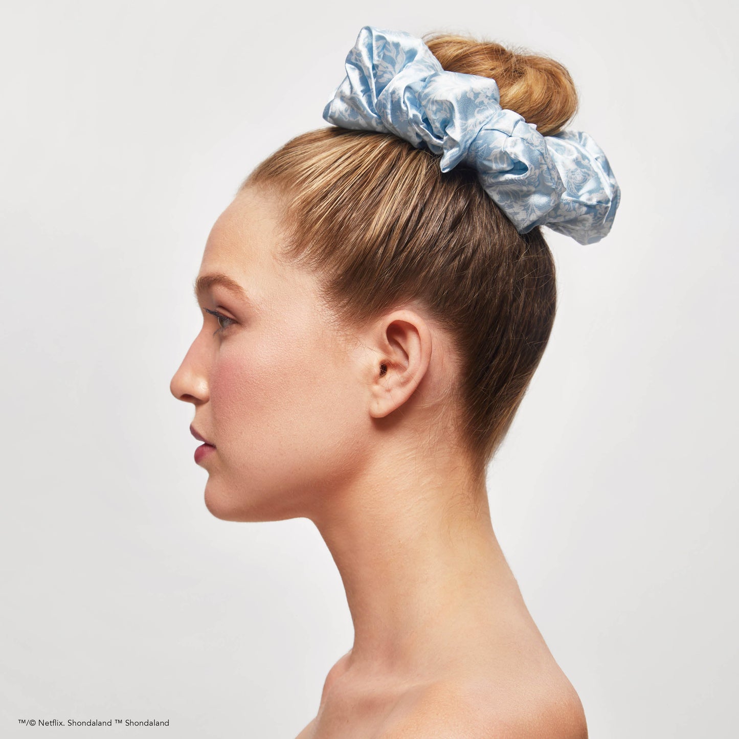 KITSCH Kitsch x Bridgerton Satin Pillow Scrunchies in Toile De Blue — model styling hair with Toile De Blue pillow scrunchie — silky satin is gentle on hair, no creasing or breakage