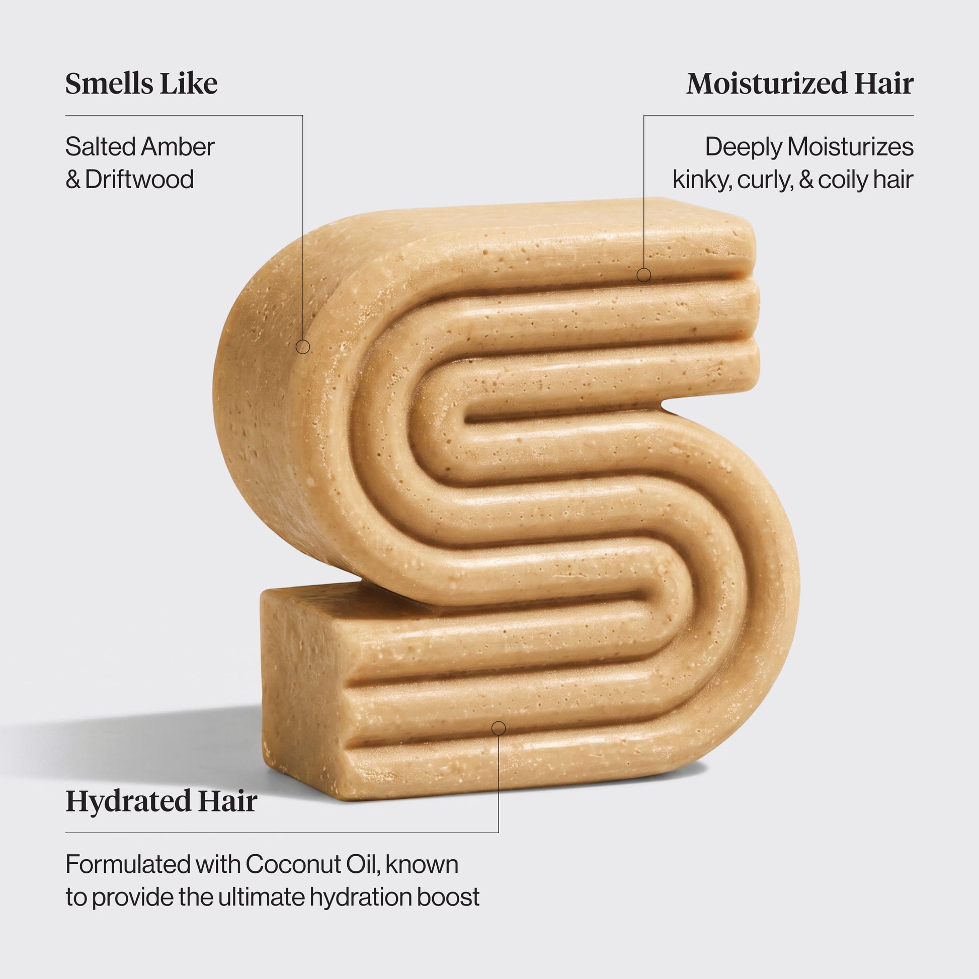 A beige, textured hair shampoo bar shaped like a stylized letter 'S' on a light gray background, with text callouts describing its scent and hair benefits.