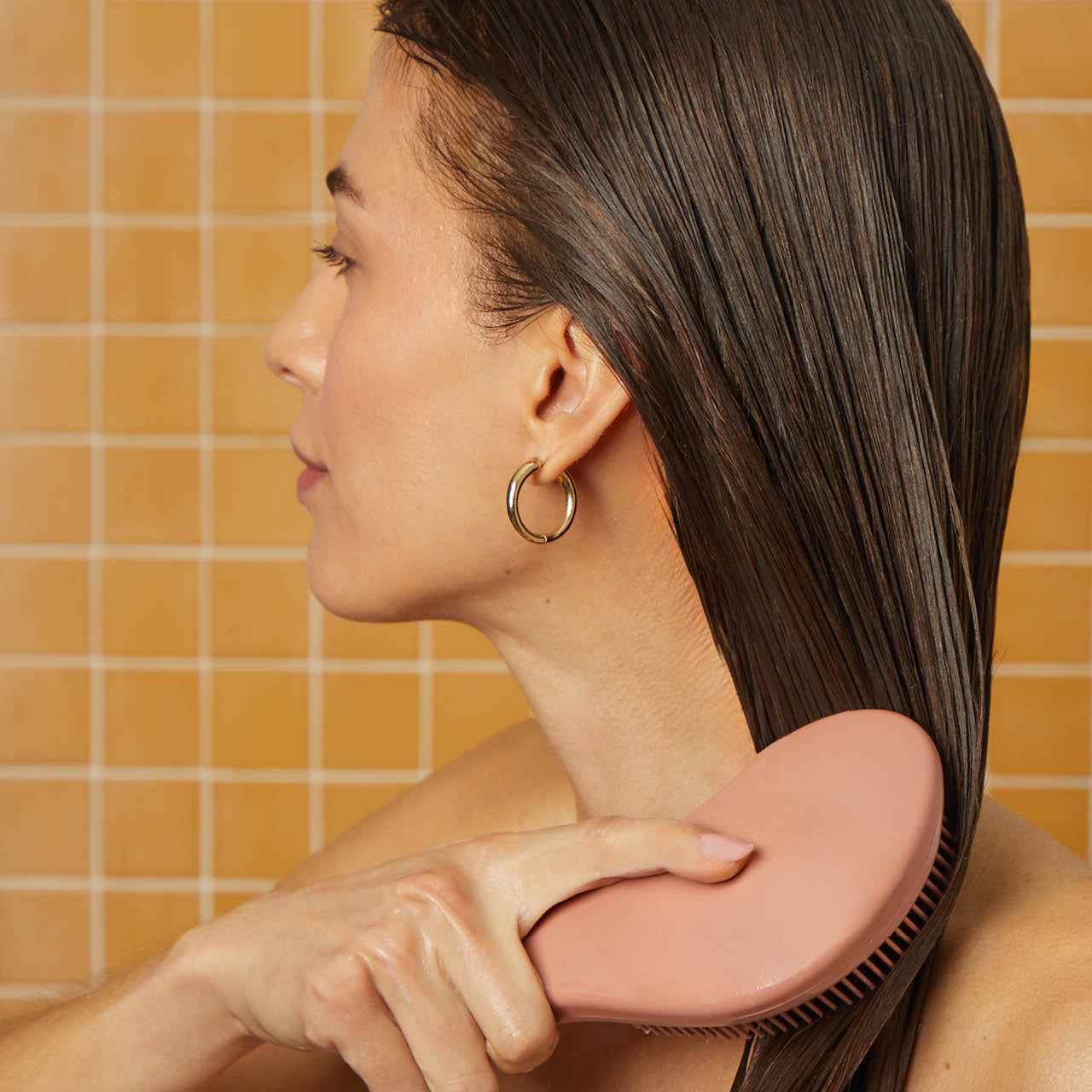 Model using the Kitsch Terracotta Detangling Brush to detangle hair