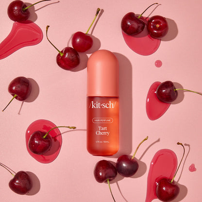 Model misting Kitsch Tart Cherry Hair Perfume onto long, glossy hair