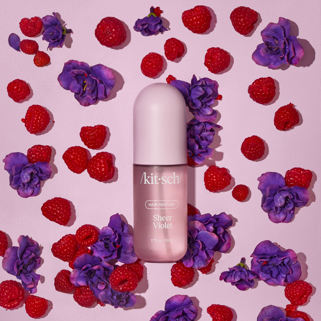 Model misting Kitsch Sheer Violet Hair Perfume onto smooth, glossy hair