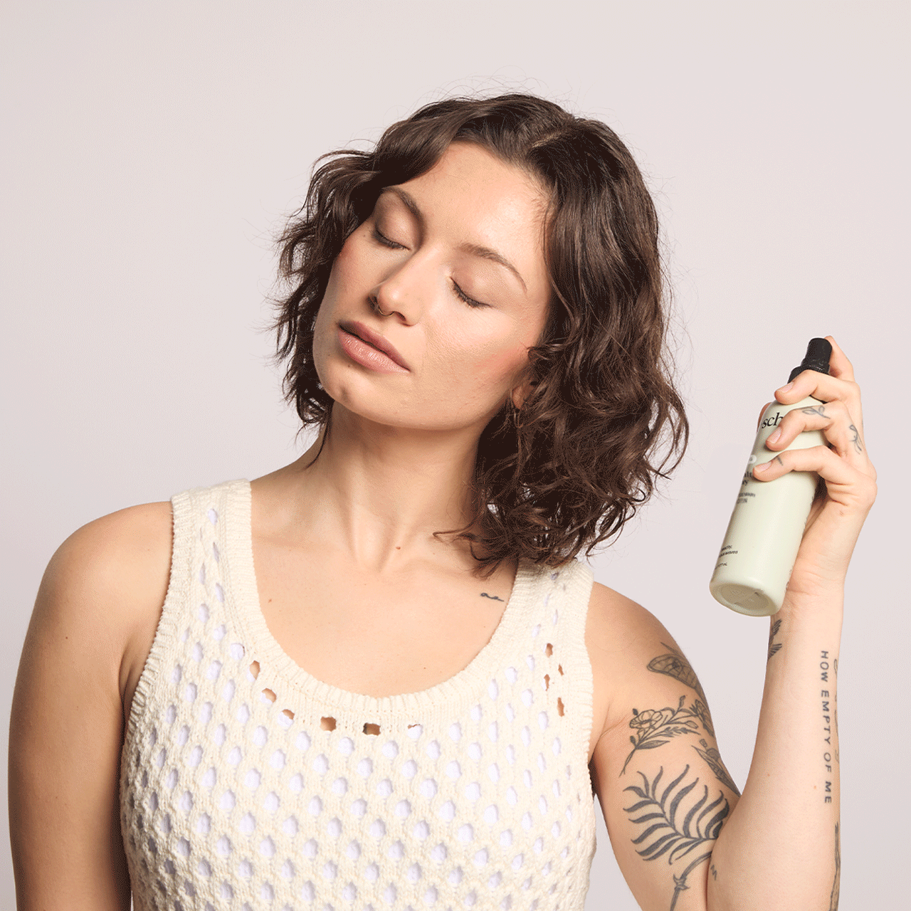 KITSCH Texturizing Sea Salt Spray — lifestyle model shot — applying spray to hair for effortless beachy wave texture — Sweet Lavender & Rosemary scent — crunch-free formula