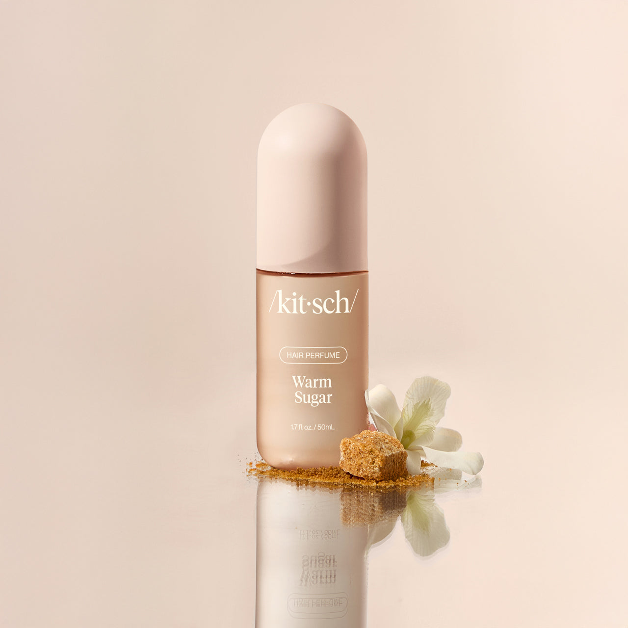 Close-up of Kitsch Warm Sugar Hair Perfume bottle showing the rose-gold spray cap