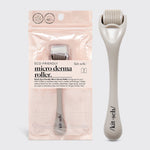 Kitsch Micro Derma Roller in Warm Gray lying flat showing fine needle wheel and handle