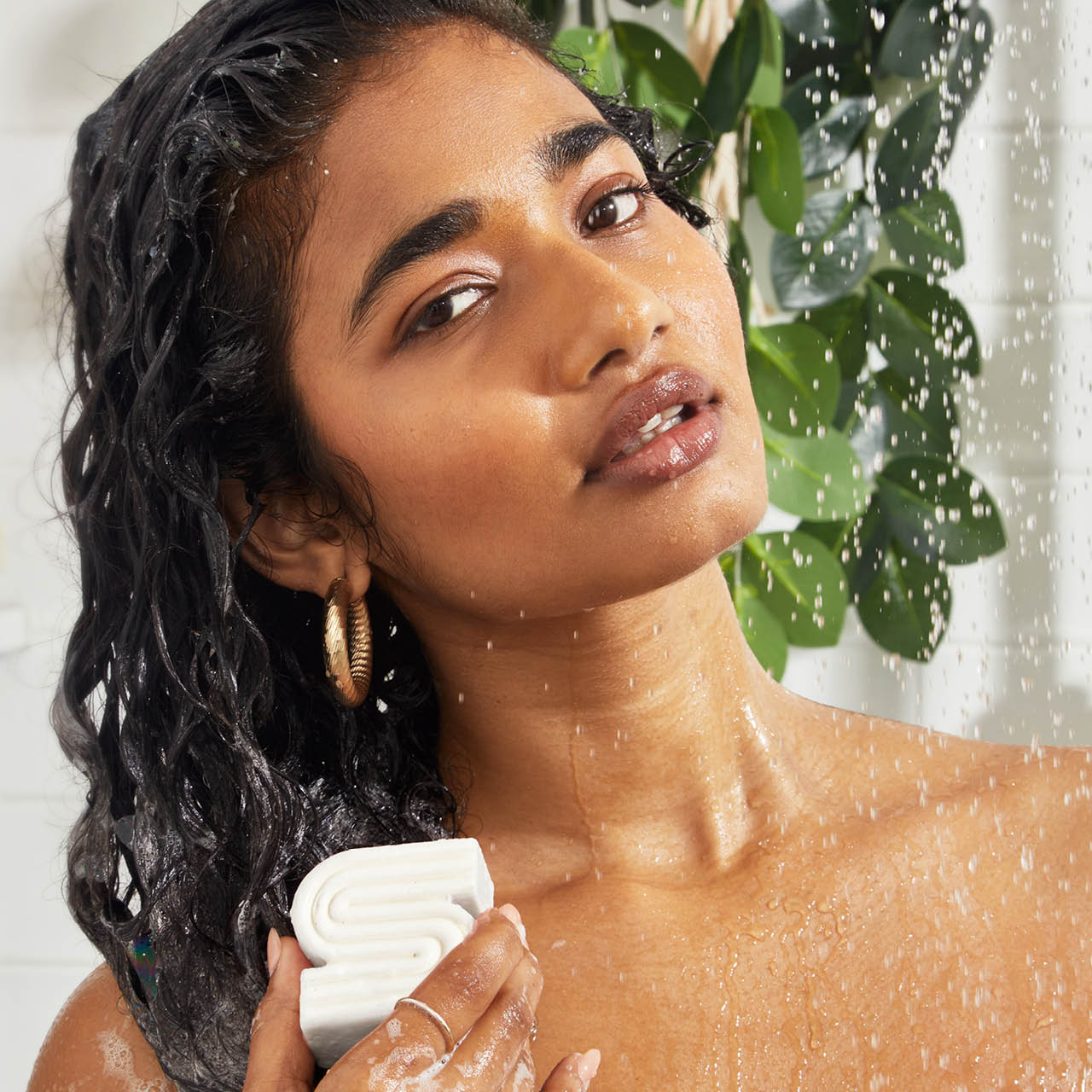 woman using a sudsy ultra sensitive solid shampoo bar on her hair