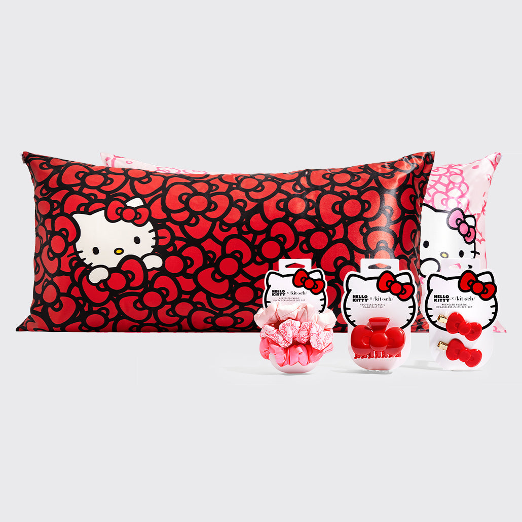Hello Kitty x KITSCH bundle featuring a red bow-print satin pillowcase, pink Hello Kitty pillowcase, scrunchie set, claw clip, and creaseless clips on a light gray background