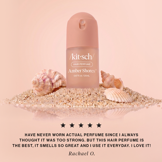 KITSCH Amber Shores Mini Hair Perfume 5-star review image — blush spray bottle on sand with seashells — quote from Rachael O.: this hair perfume is the best, it smells so great and I use it everyday