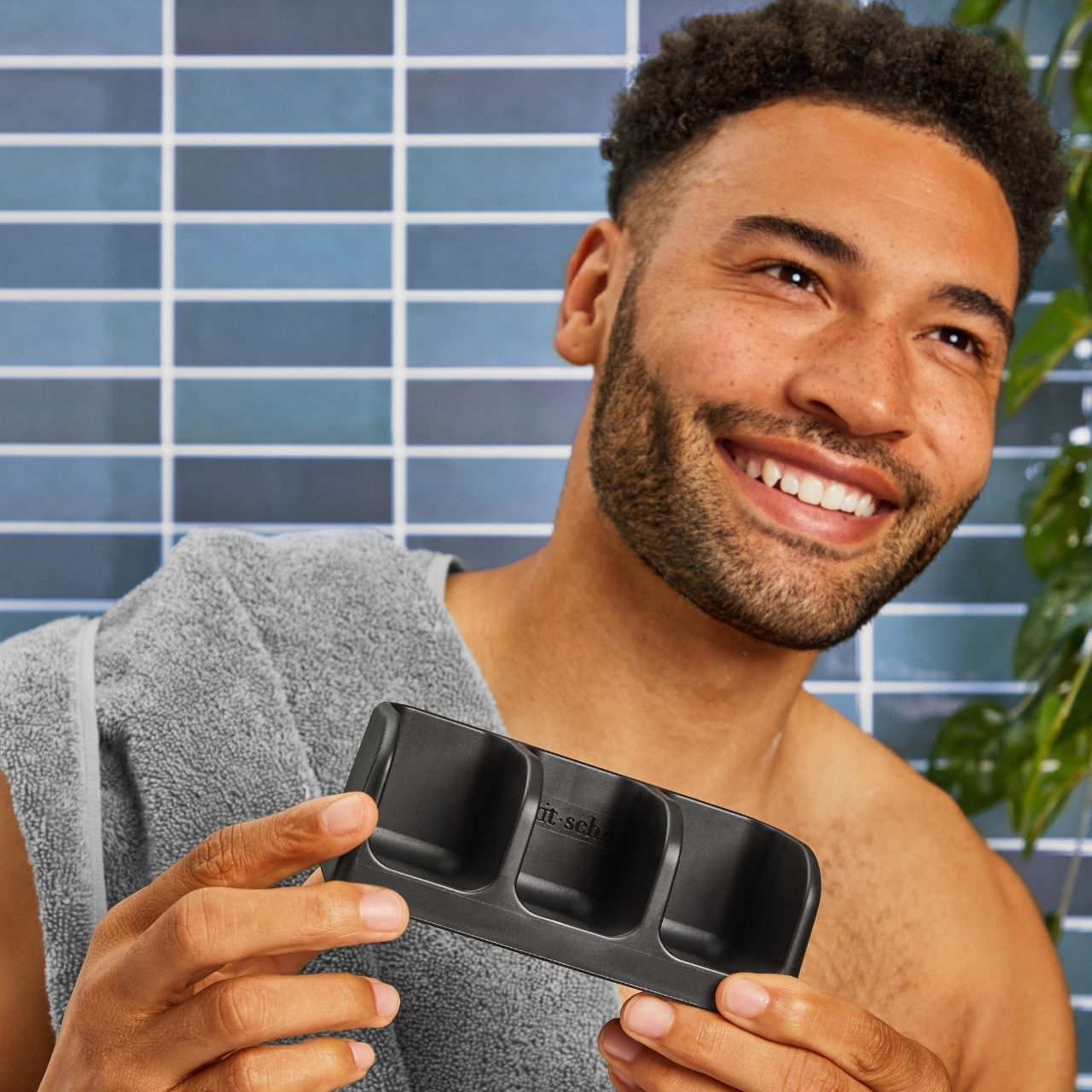 Person holding the Kitsch Self-Draining Triple Soap Dish designed to keep solid shampoo, conditioner, and body wash bars dry.