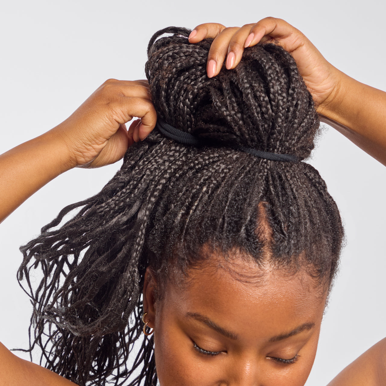 Model with braided hair styling high bun using Kitsch Recycled Nylon Thick Elastic in Black